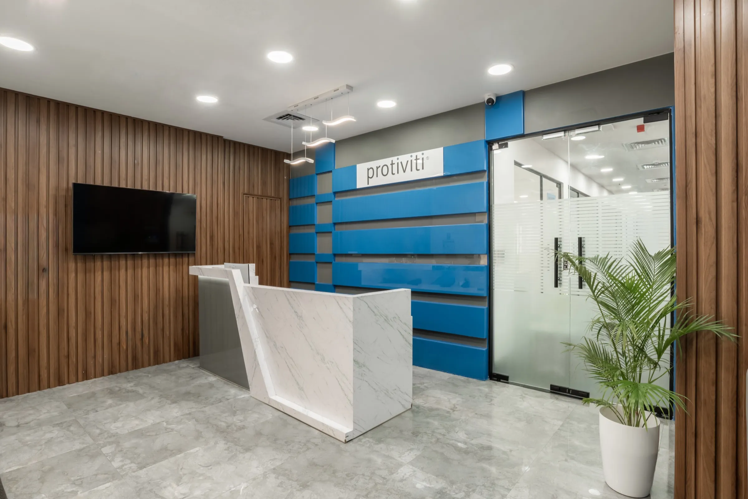 Reception desk against a blue feature wall framed by timber slats